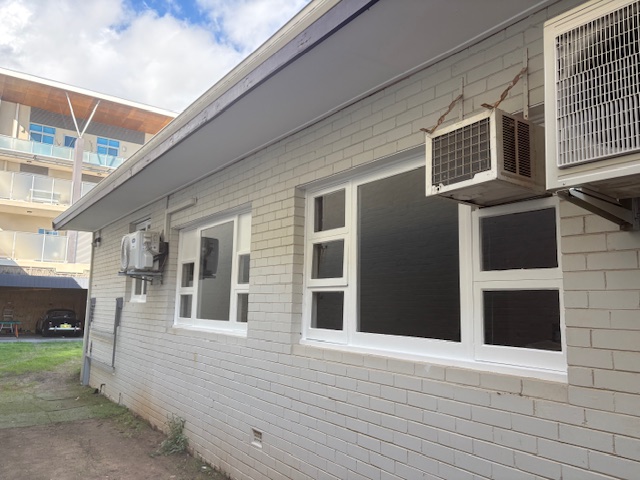 eaves (2) Brick building exterior with air conditioning units.